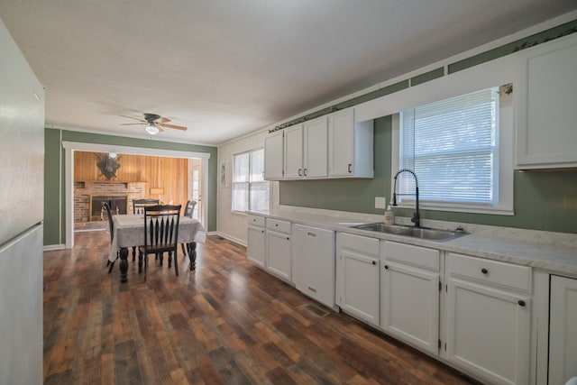 kitchen with white appliances, sink, white cabinetry, ceiling fan, and dark wood-type flooring