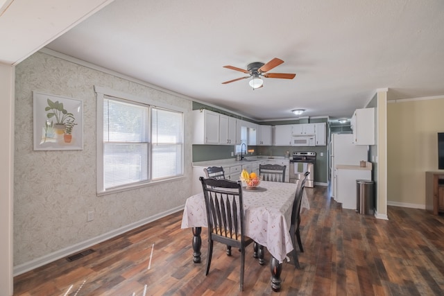 dining area featuring ornamental molding, sink, dark wood-type flooring, and ceiling fan