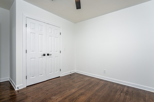 unfurnished bedroom with a closet, dark wood-type flooring, and ceiling fan