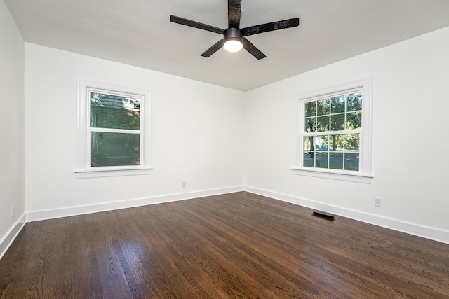 empty room featuring dark wood-type flooring and ceiling fan