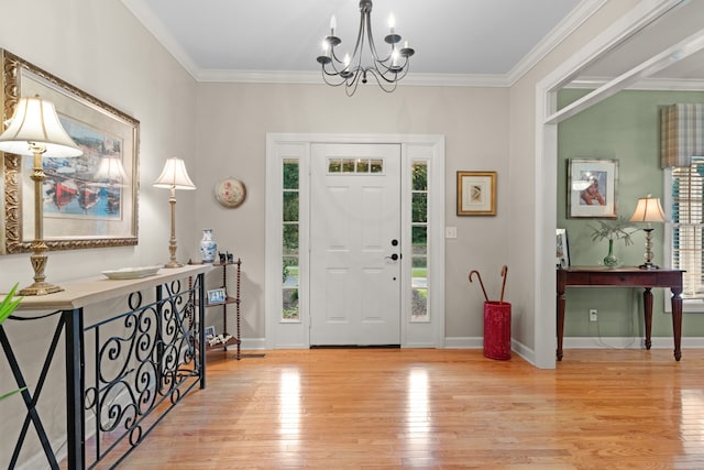 foyer featuring ornamental molding, a chandelier, and light wood-type flooring