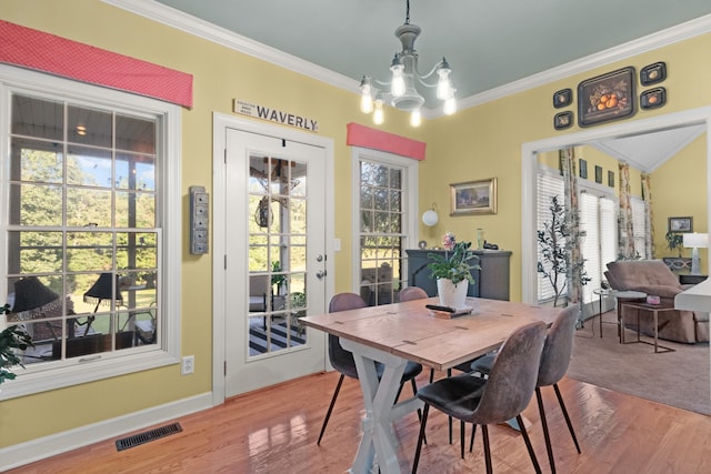 dining area featuring ornamental molding, hardwood / wood-style flooring, and plenty of natural light