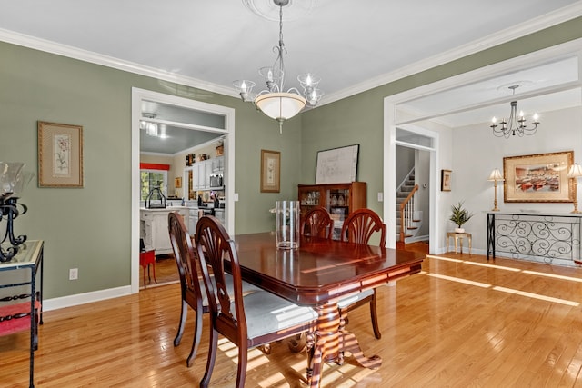 dining space with light hardwood / wood-style floors, a notable chandelier, and ornamental molding