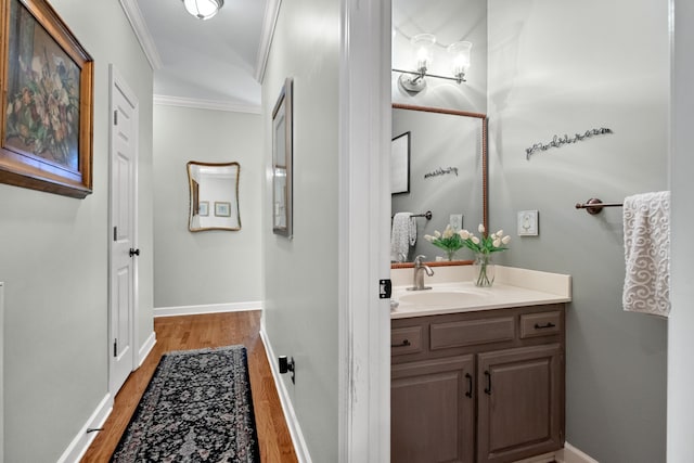 bathroom with vanity, crown molding, and wood-type flooring