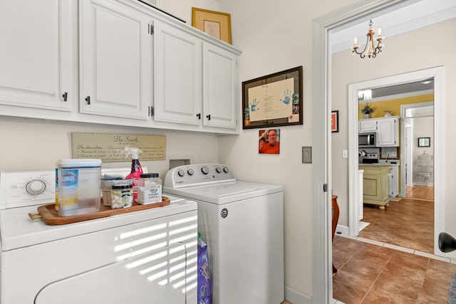 clothes washing area with crown molding, cabinets, a chandelier, and washing machine and clothes dryer