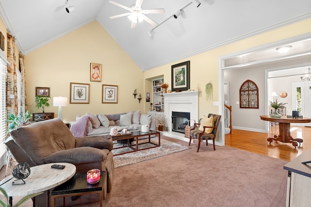 living room with light hardwood / wood-style floors, track lighting, high vaulted ceiling, and ceiling fan