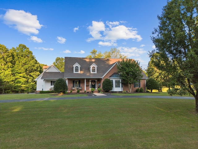 cape cod house featuring covered porch and a front lawn