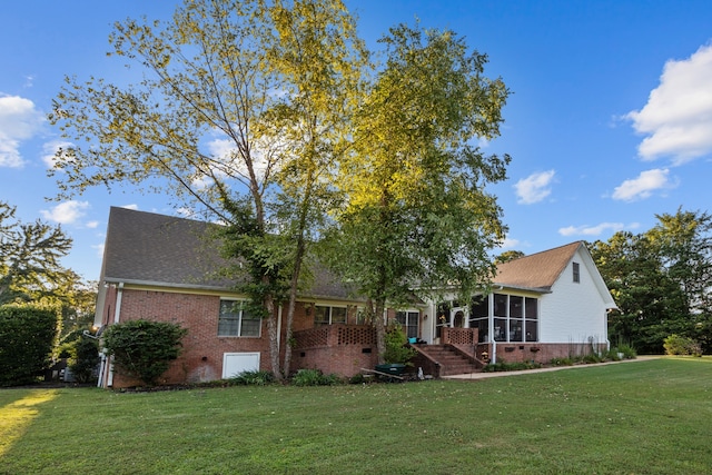 view of front of home featuring a sunroom and a front lawn