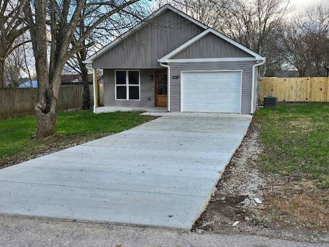 view of front facade featuring a front lawn, cooling unit, and a garage