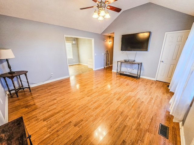 living room featuring light hardwood / wood-style flooring, lofted ceiling, and ceiling fan