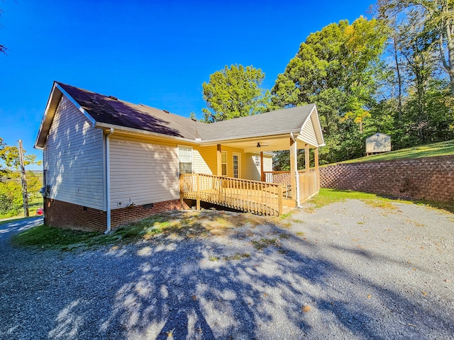 view of front facade featuring a wooden deck and ceiling fan