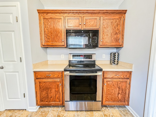 kitchen featuring a textured ceiling and stainless steel electric range oven