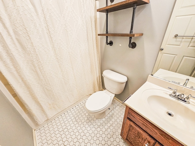 bathroom featuring toilet, curtained shower, vanity, and tile patterned floors