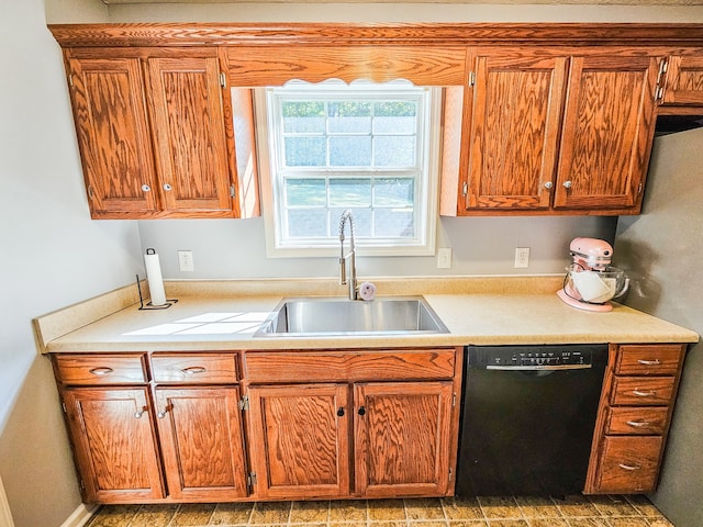 kitchen featuring black dishwasher, sink, and stainless steel fridge