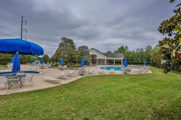 view of swimming pool featuring a patio and a yard