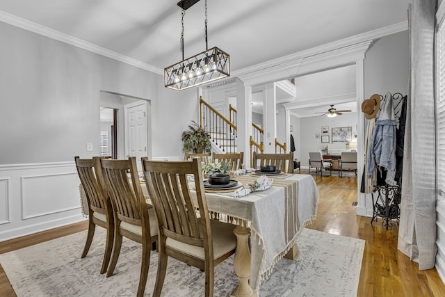 dining area featuring ornamental molding, hardwood / wood-style flooring, and ceiling fan with notable chandelier