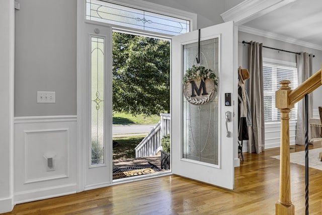 entryway with ornamental molding, hardwood / wood-style floors, and plenty of natural light