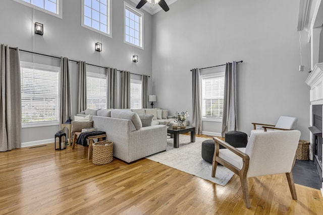 living room with a healthy amount of sunlight, a high ceiling, and light wood-type flooring