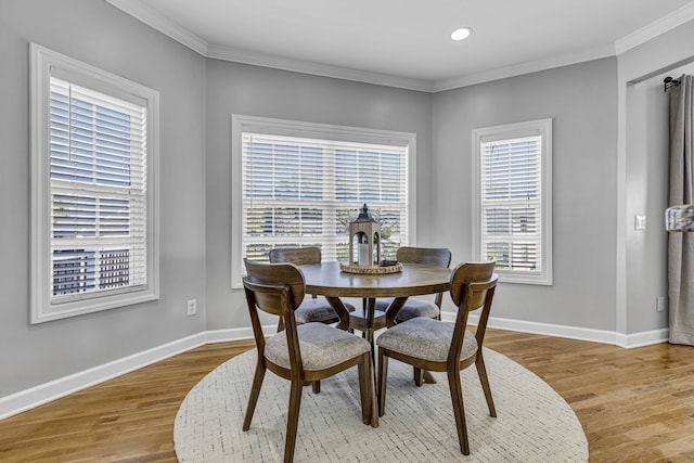 dining area featuring ornamental molding and light hardwood / wood-style flooring