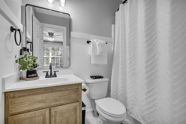 bathroom featuring toilet, a shower with curtain, vanity, and ceiling fan