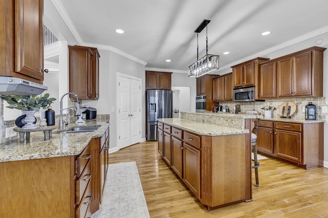 kitchen featuring light hardwood / wood-style floors, appliances with stainless steel finishes, sink, and hanging light fixtures