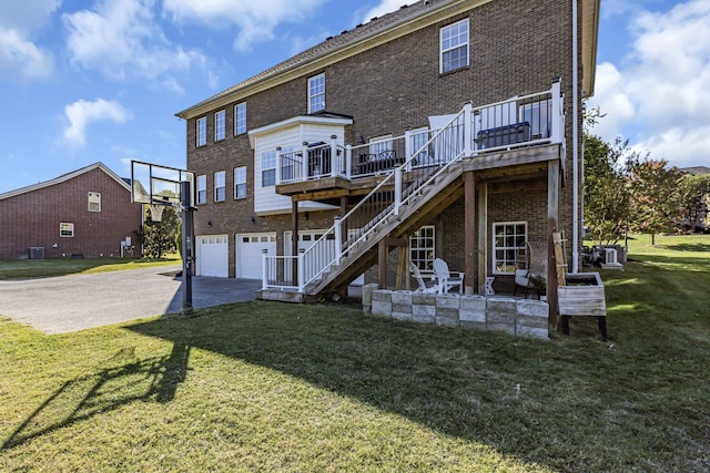 rear view of property with central AC, a deck, a yard, and a garage