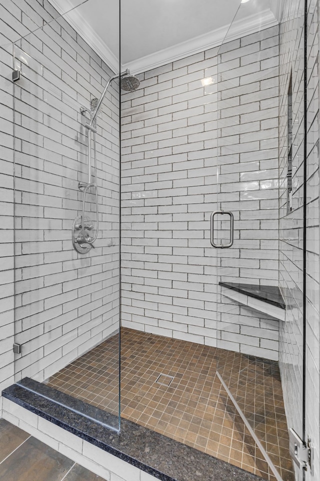 bathroom with crown molding and a shower with shower door