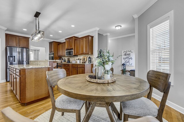 dining space featuring light hardwood / wood-style floors and crown molding