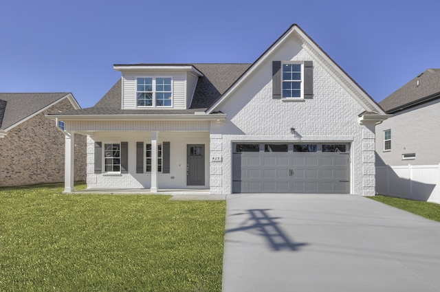 view of front of house with a front lawn, covered porch, and a garage