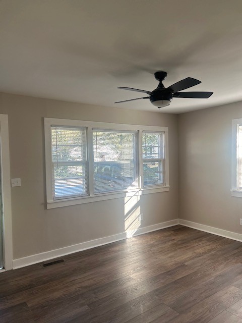 unfurnished room featuring dark wood-type flooring and ceiling fan