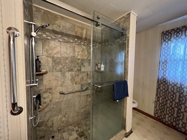 bathroom with a shower with door and toilet