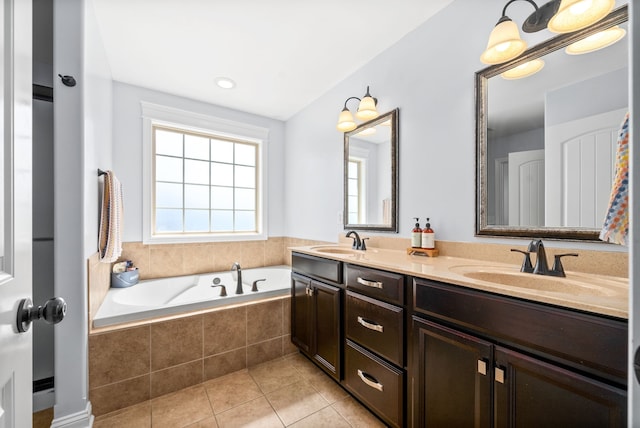 bathroom with vanity, tiled tub, and tile patterned flooring