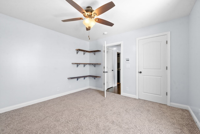 unfurnished bedroom featuring ceiling fan and dark carpet