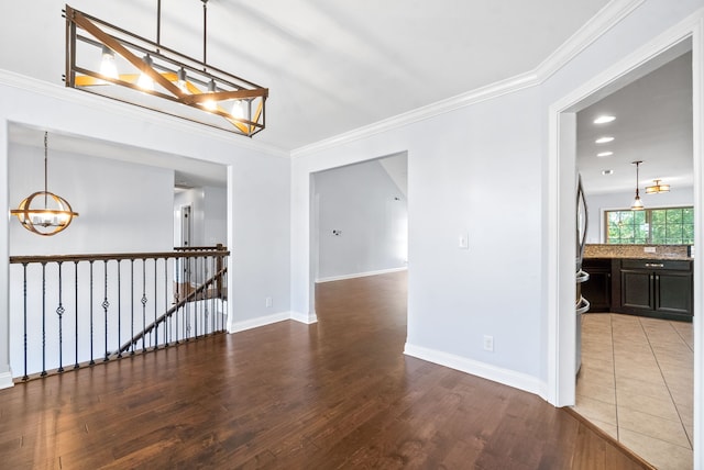 interior space featuring crown molding, an inviting chandelier, and hardwood / wood-style floors