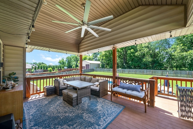 wooden terrace with ceiling fan, a storage unit, and outdoor lounge area