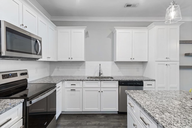 kitchen featuring dark hardwood / wood-style floors, sink, pendant lighting, white cabinetry, and appliances with stainless steel finishes