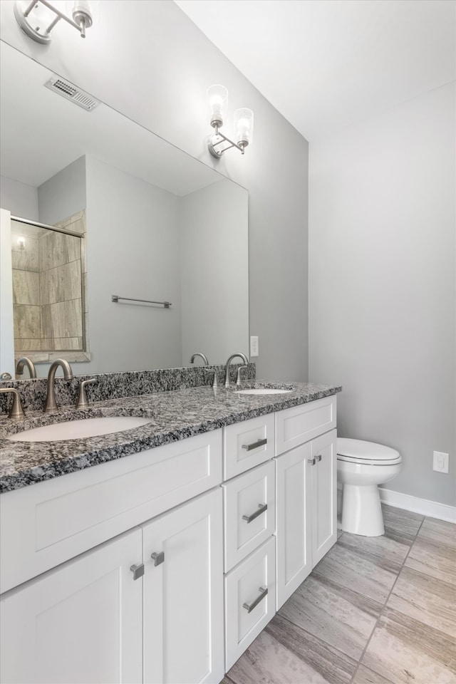 bathroom with vanity, wood-type flooring, toilet, and walk in shower