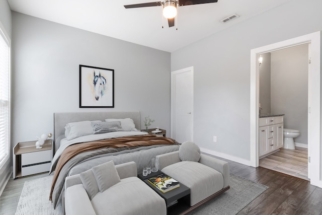 bedroom featuring ceiling fan, ensuite bathroom, and dark hardwood / wood-style floors