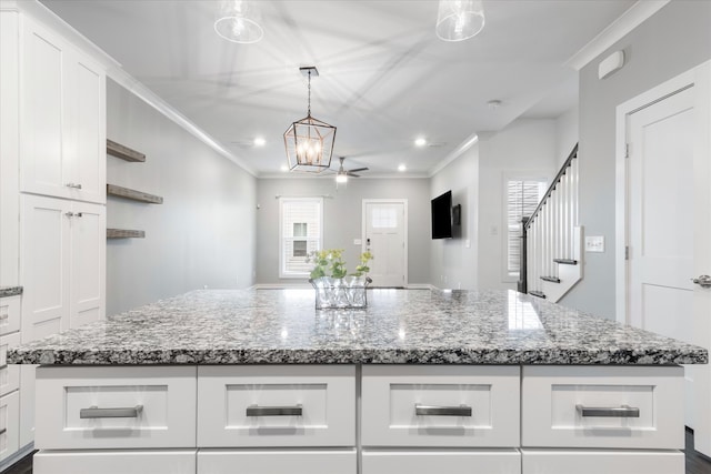 kitchen featuring a center island, white cabinetry, and crown molding