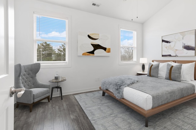 bedroom with lofted ceiling, multiple windows, and dark hardwood / wood-style floors