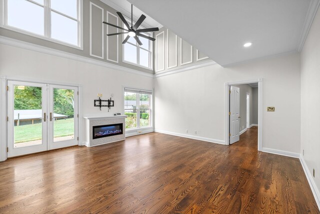 2264 Lock B Rd N, Clarksville, TN 37043 - unfurnished living room with ceiling fan, a glass covered fireplace, a towering ceiling, crown molding, and dark wood-style flooring
