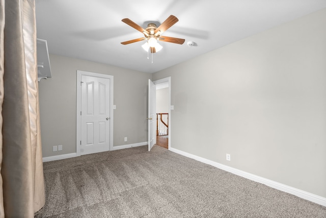 carpeted spare room featuring ceiling fan