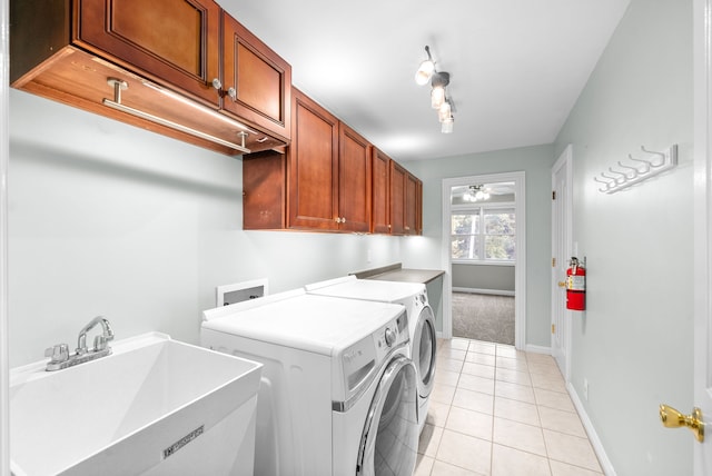 washroom featuring washing machine and dryer, sink, ceiling fan, cabinets, and light tile patterned floors