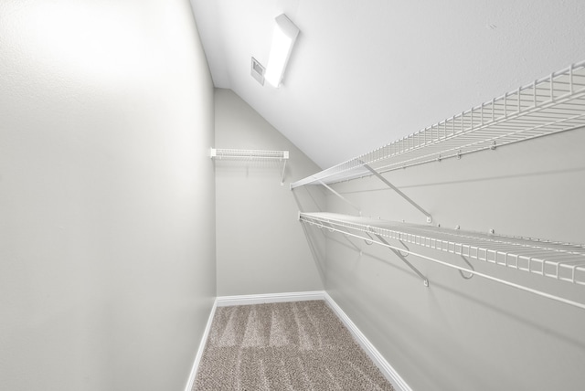 walk in closet with carpet flooring and lofted ceiling