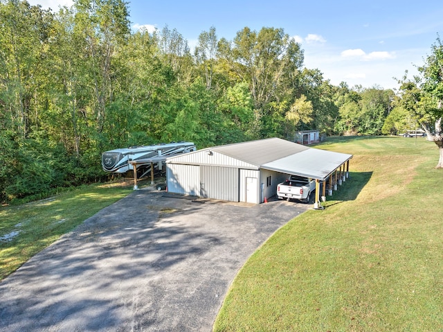 view of front of property featuring a carport, a front yard, an outbuilding, and a garage