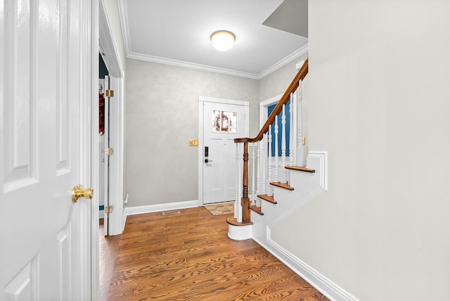 foyer with ornamental molding and hardwood / wood-style flooring