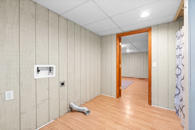 washroom with wooden walls, light hardwood / wood-style flooring, electric dryer hookup, and hookup for a washing machine