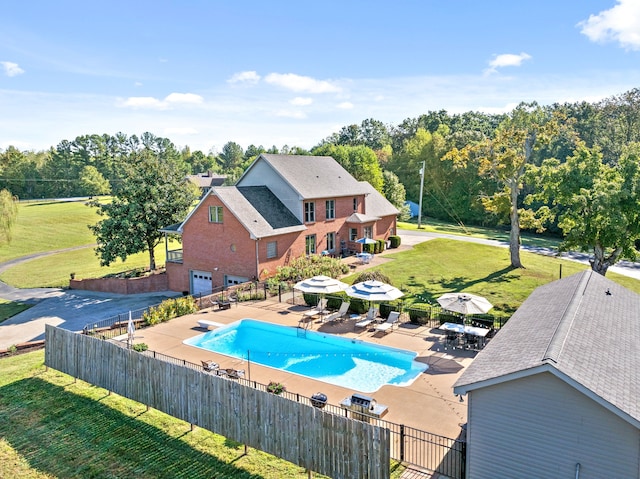 view of swimming pool featuring a yard, a diving board, and a patio