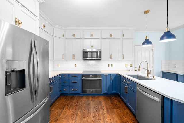 kitchen featuring dark wood-type flooring, sink, decorative light fixtures, blue cabinetry, and appliances with stainless steel finishes