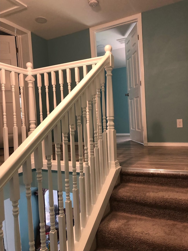 stairs featuring baseboards and wood finished floors
